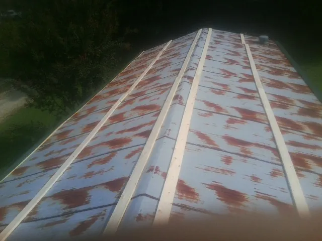 Rusted metal roof panels with new wood purlins before replacement — Storm Damage Roof Repair in Yorklyn by Roofing Brothers