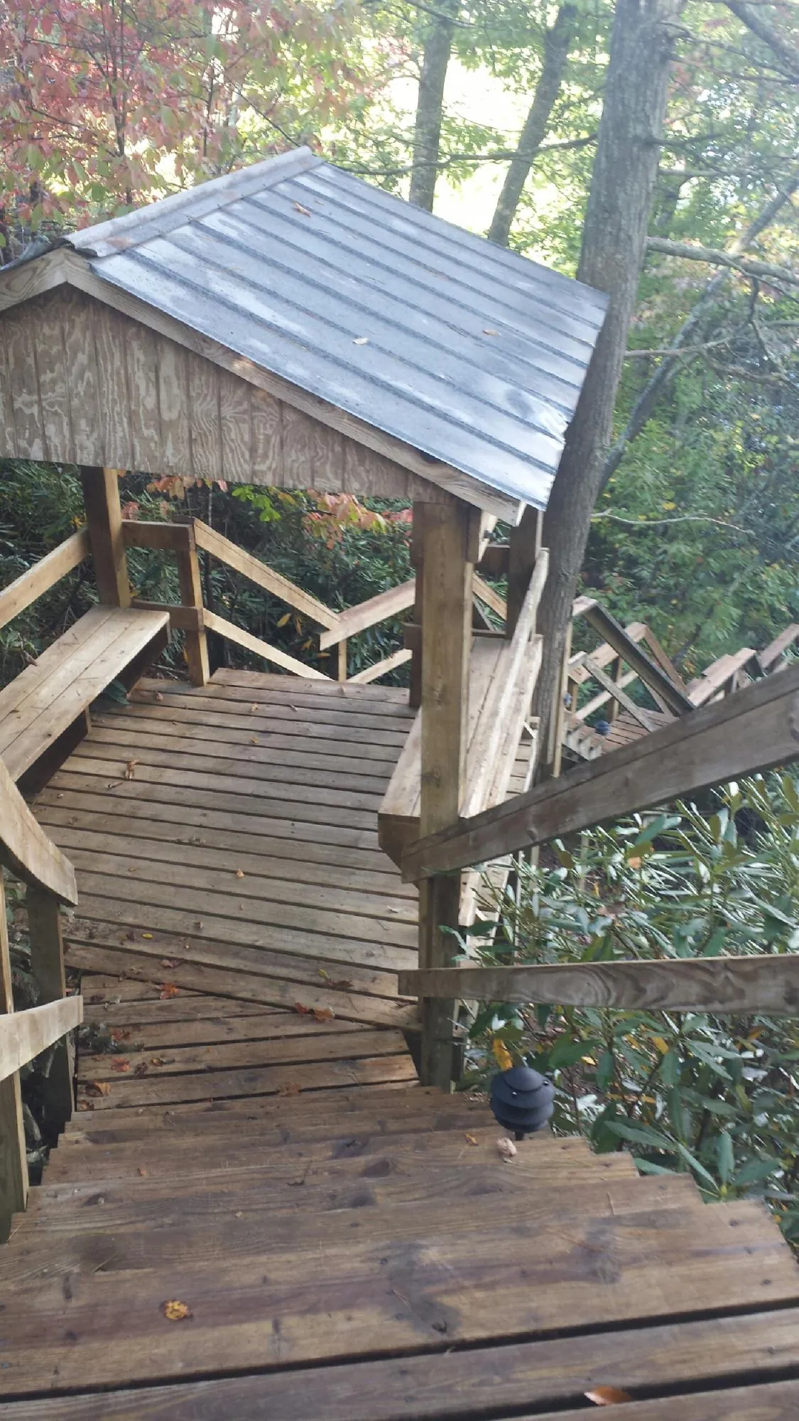 Metal roofed shelter over wooden steps on a wooded walkway — Skylight Repair & Installation work by our crew in Yorklyn